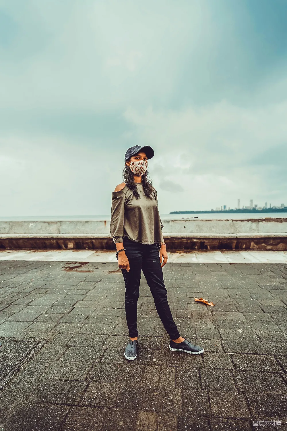 高清摄影 人物 穿着灰色外套和黑色裤子的女人站在灰色混凝土地面上，白天。