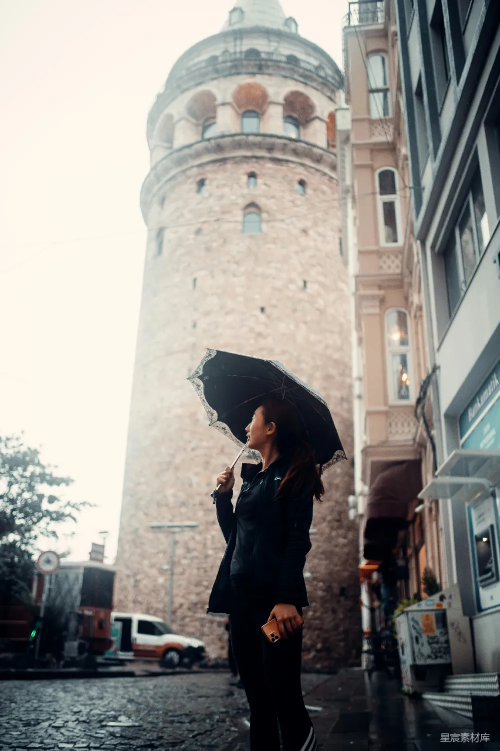 高清摄影  一个撑着雨伞的女人站在雨中。