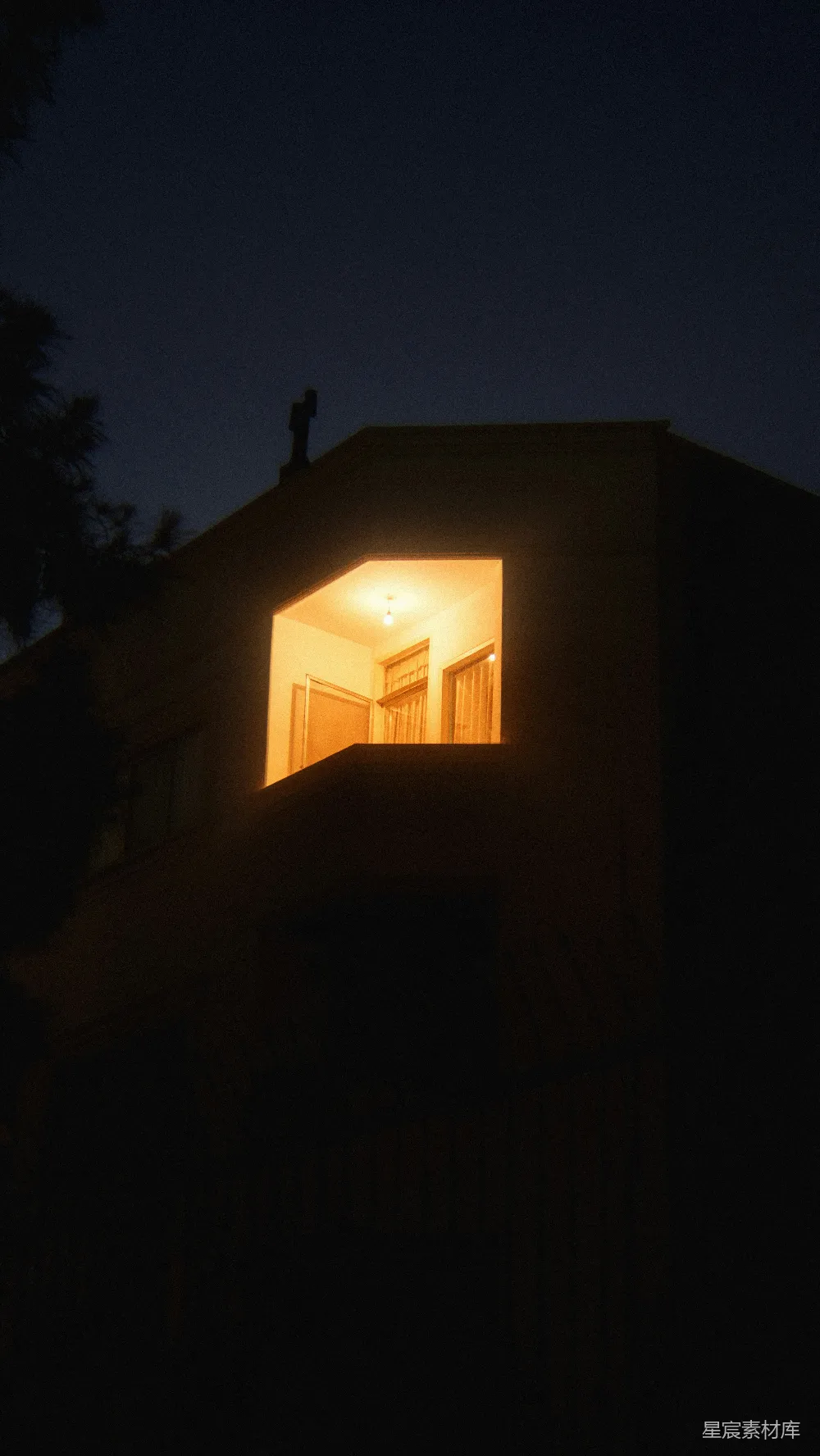 高清摄影  夜晚，一座昏暗建筑中一扇明亮的窗户。