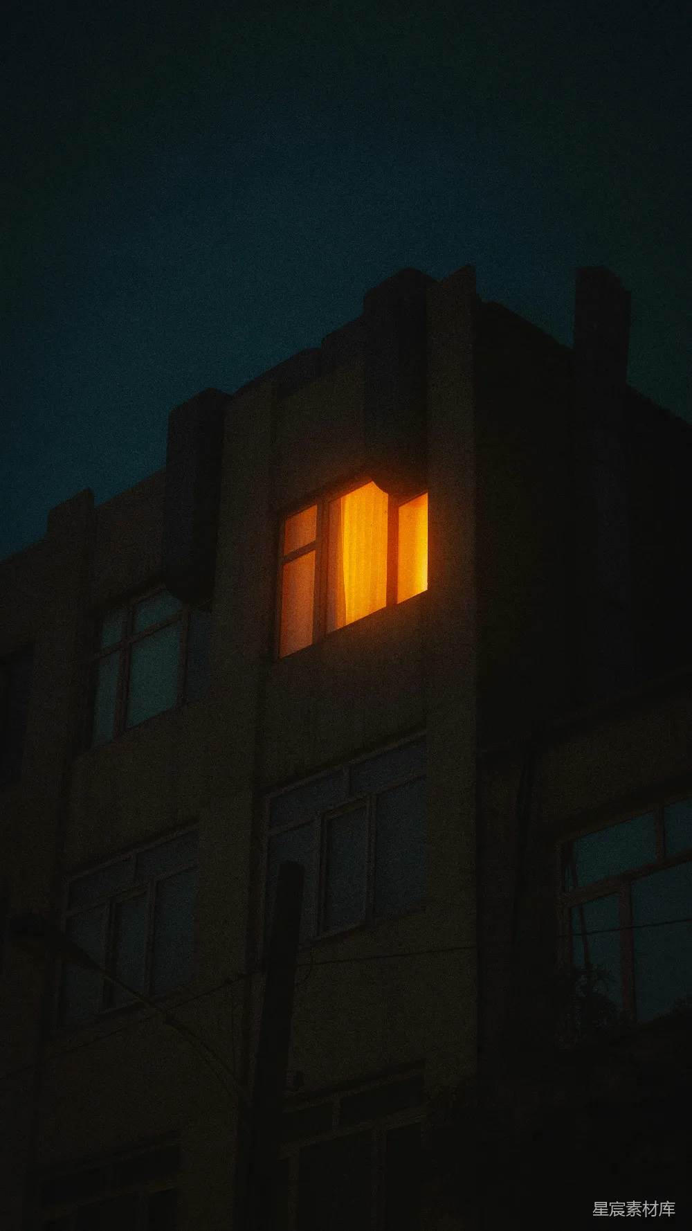 高清摄影 壁纸 夜晚，一扇窗户发出温暖的橙色光芒。