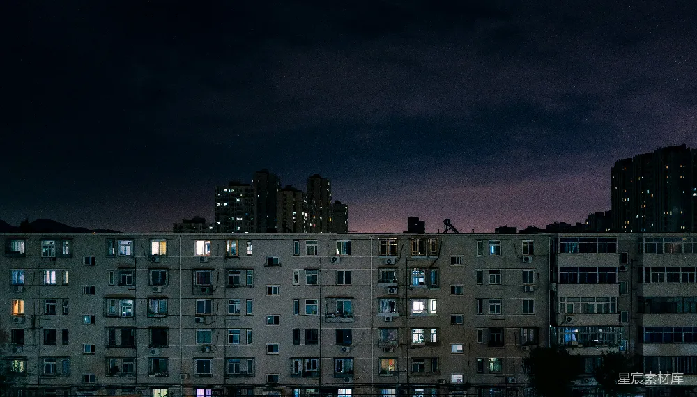 高清摄影  夜晚在黑暗的天空下，公寓楼被照亮。
