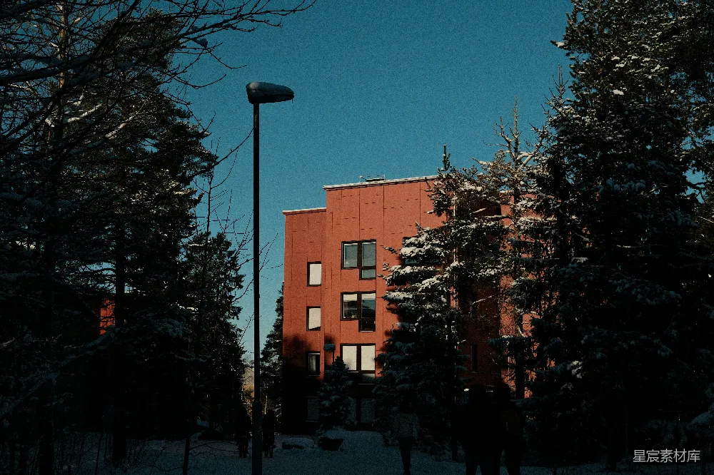 高清摄影  现代红色建筑周围环绕着覆盖着雪的树木。