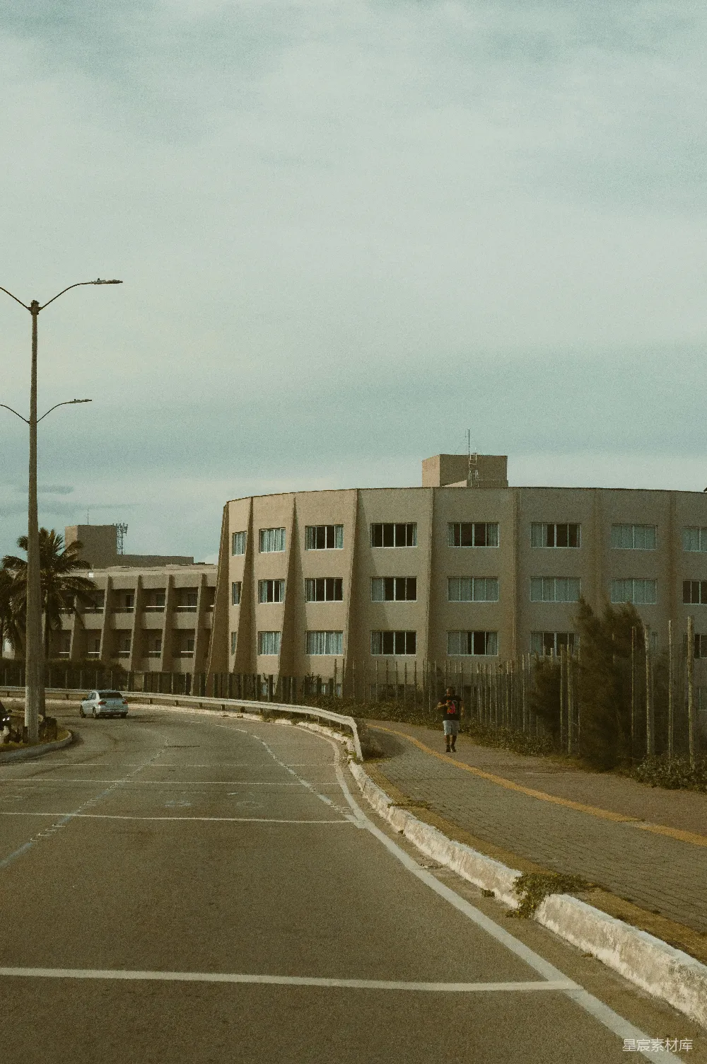 高清摄影  现代建筑沿着一条蜿蜒的道路排列，天空阴云密布。