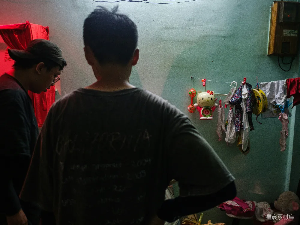 高清摄影  两个昏暗房间中挂着衣服的人。