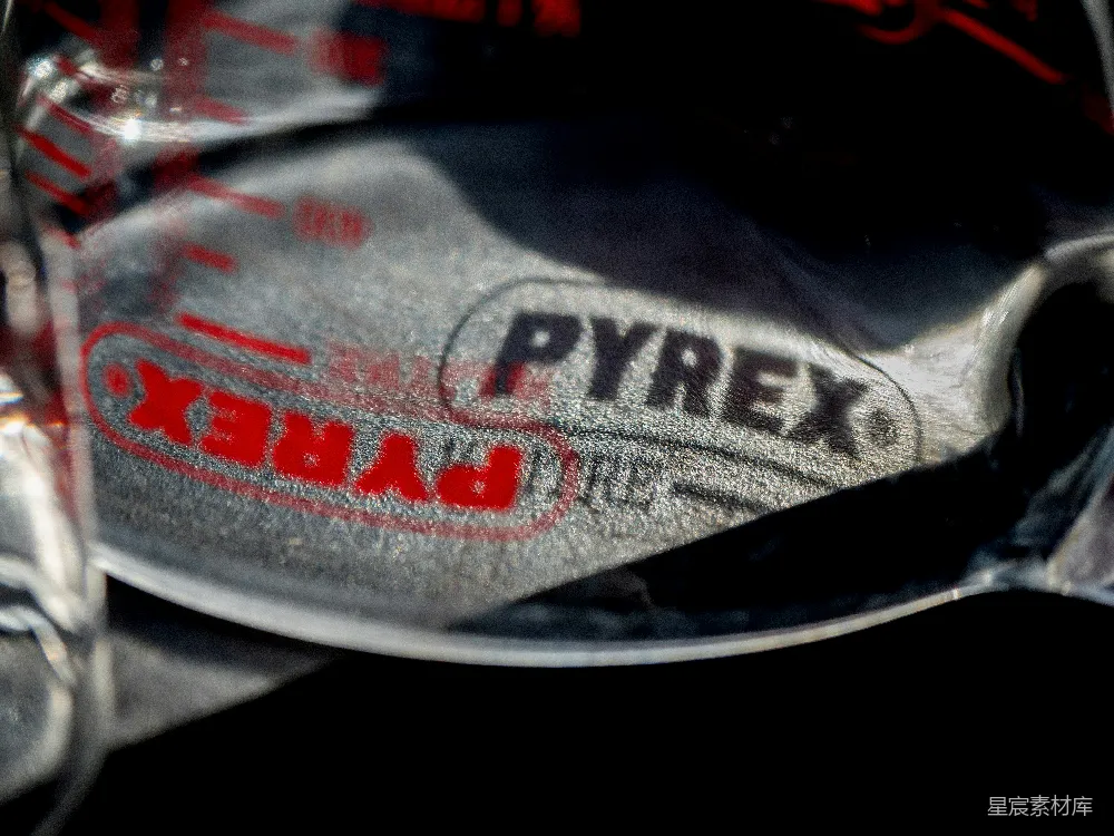 高清摄影  玻璃器皿品牌Pyrex标志特写，背景是皱巴巴的金属。