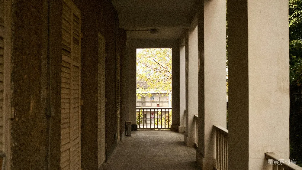 高清摄影  一条长长的空走廊，尽头有自然光照射进来。