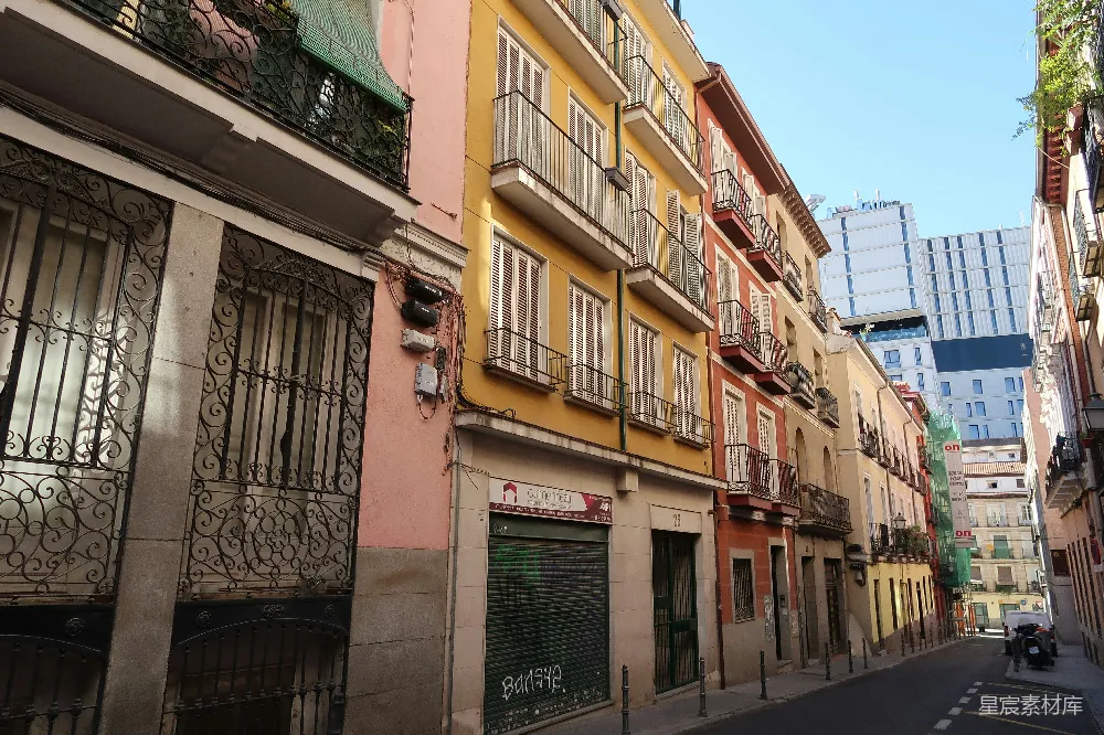 高清摄影  一条狭窄的街道，两旁是色彩斑斓的住宅楼和阳台。