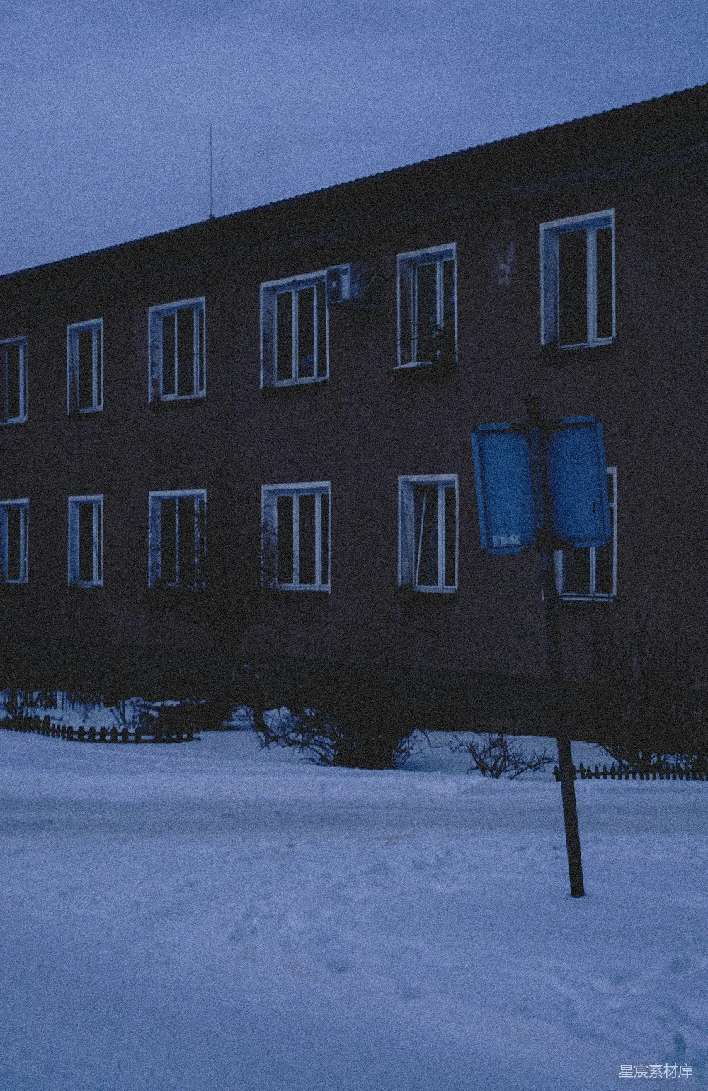 高清摄影  被雪覆盖的地面和蓝色标志的黑暗建筑物