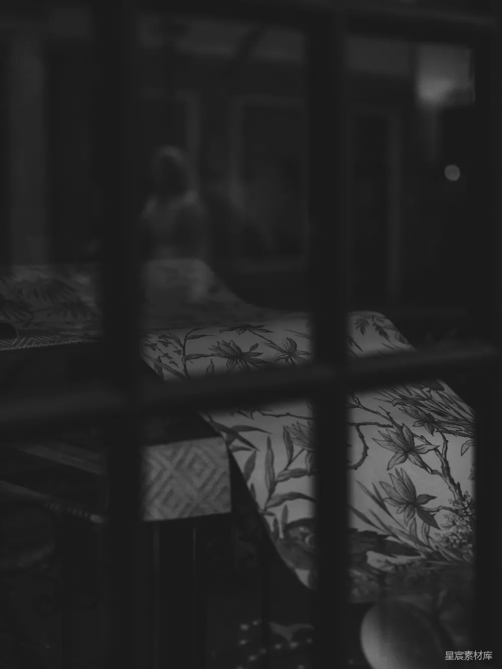 高清摄影  一间昏暗的房间，床上铺着有图案的枕头。