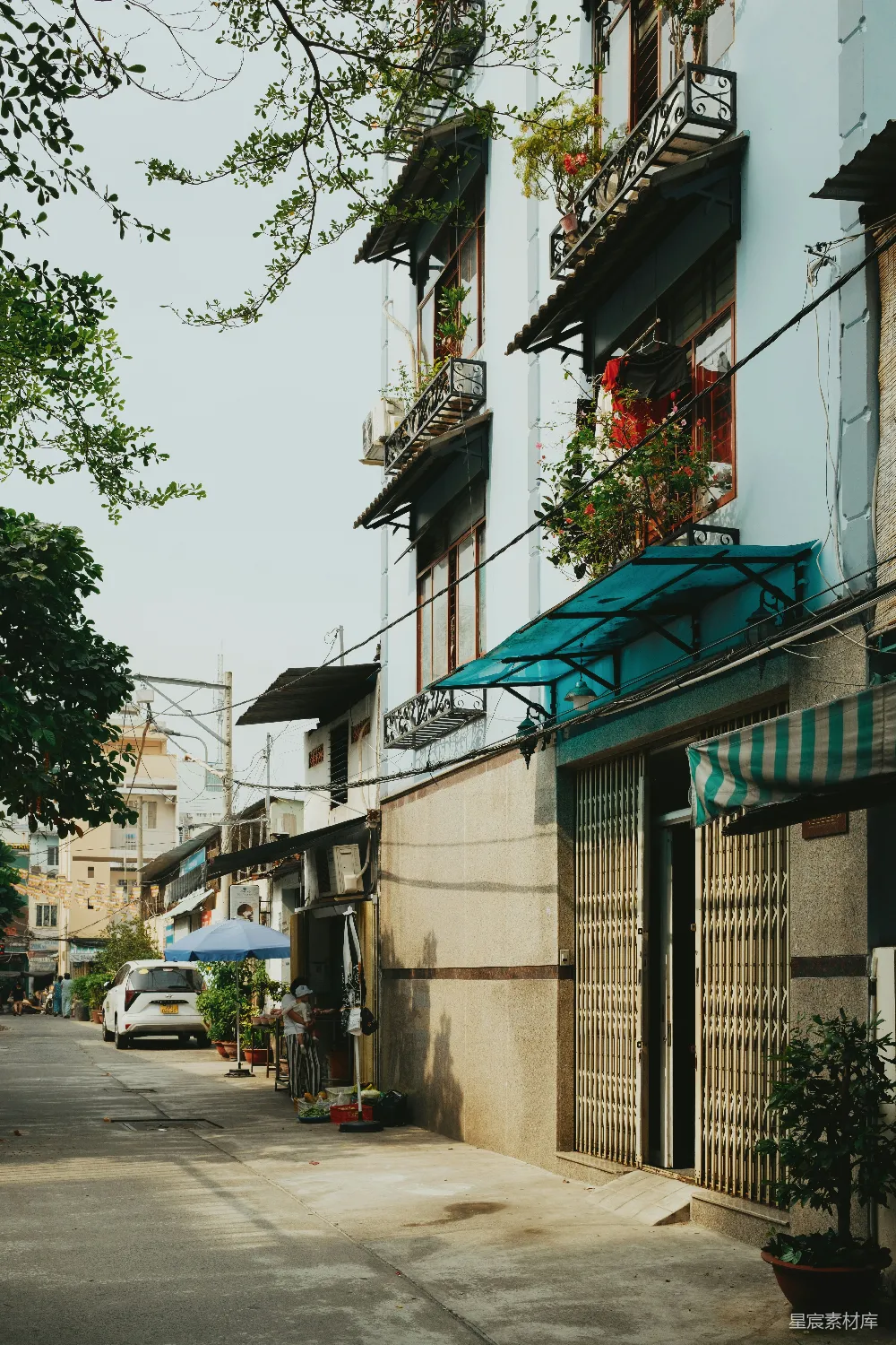高清摄影  狭窄街道两旁是住宅楼和树木。