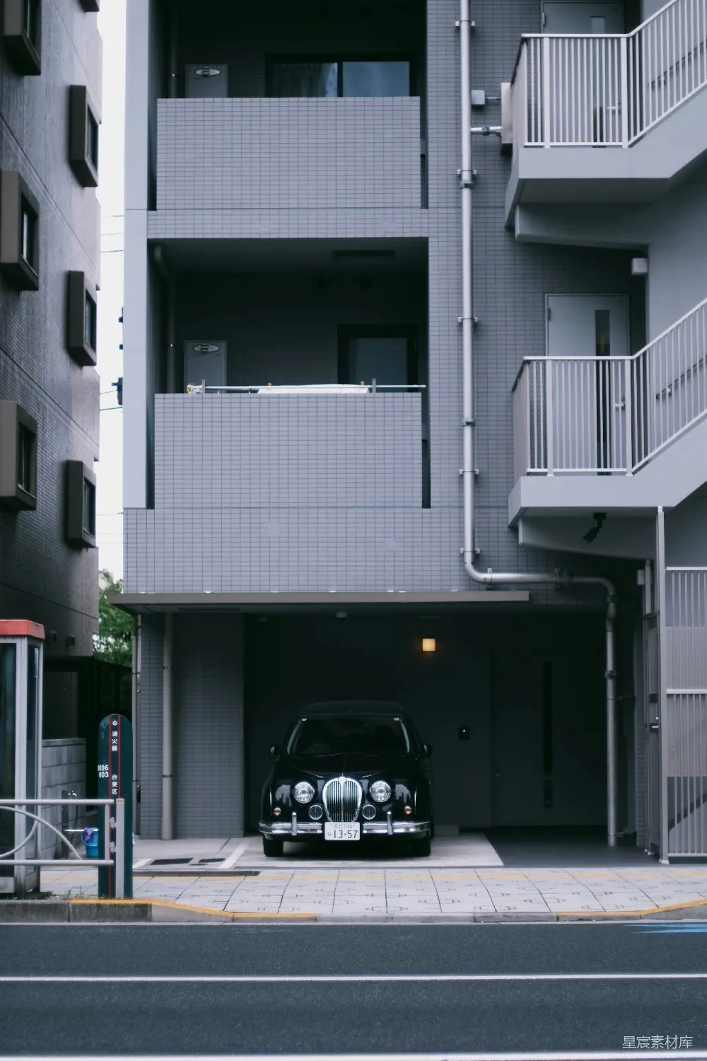 高清摄影  一辆复古的黑色汽车停在一座灰色的都市建筑内。