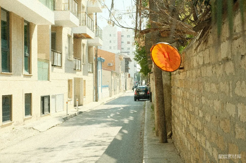 高清摄影  一条狭窄的街道，两旁是建筑物和一个交通镜。