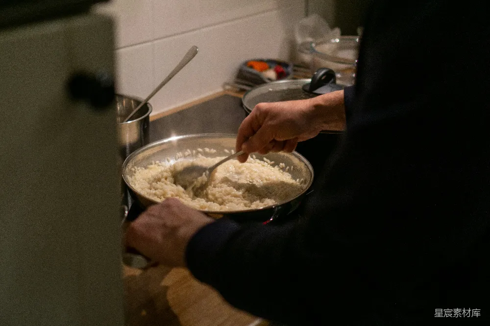 高清摄影  一个人在炉子上搅拌一碗食物。