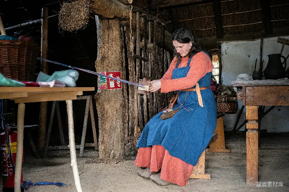 高清摄影  穿着历史服饰的女人正在使用工具