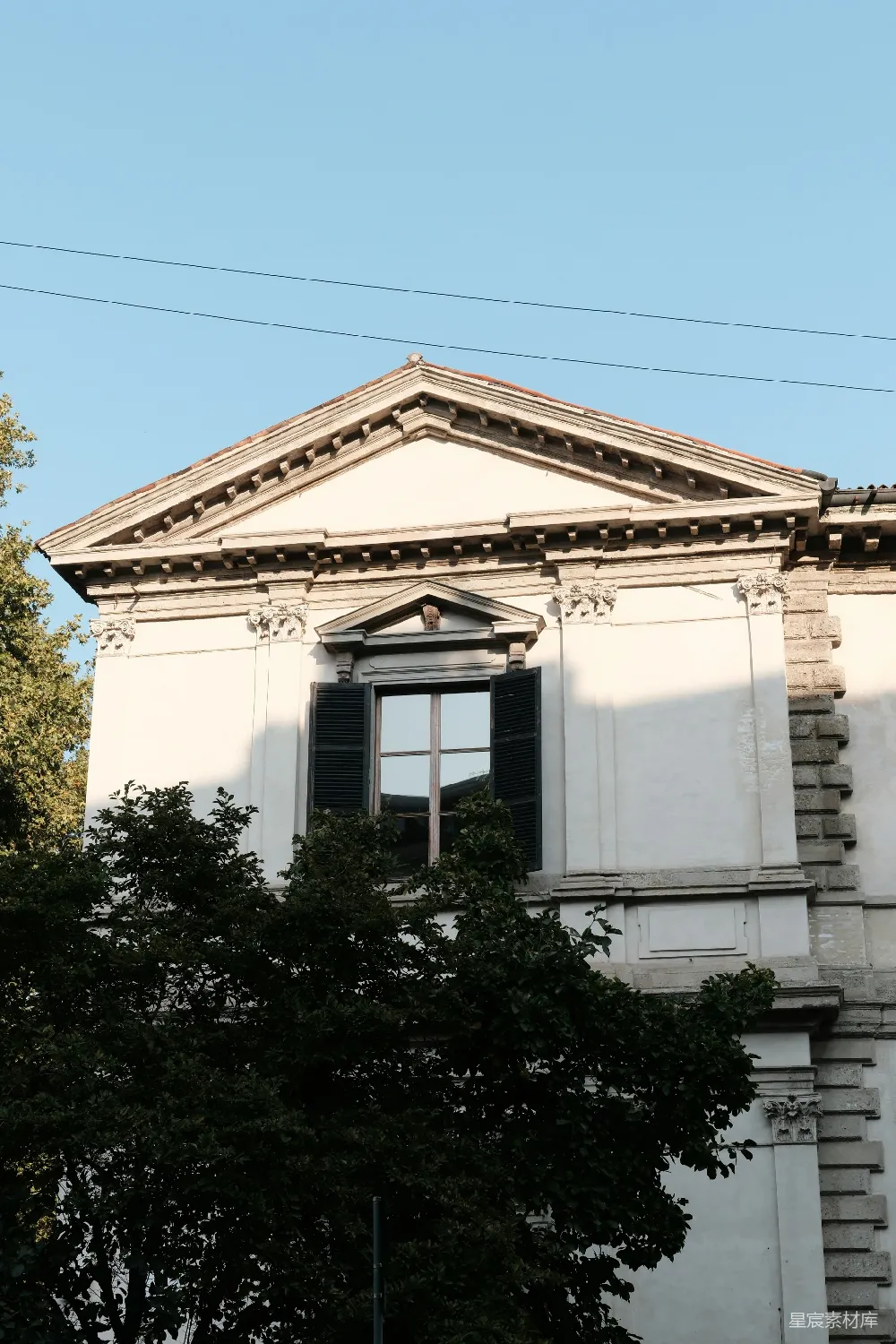 高清摄影  古典建筑立面，带有窗户和树木。