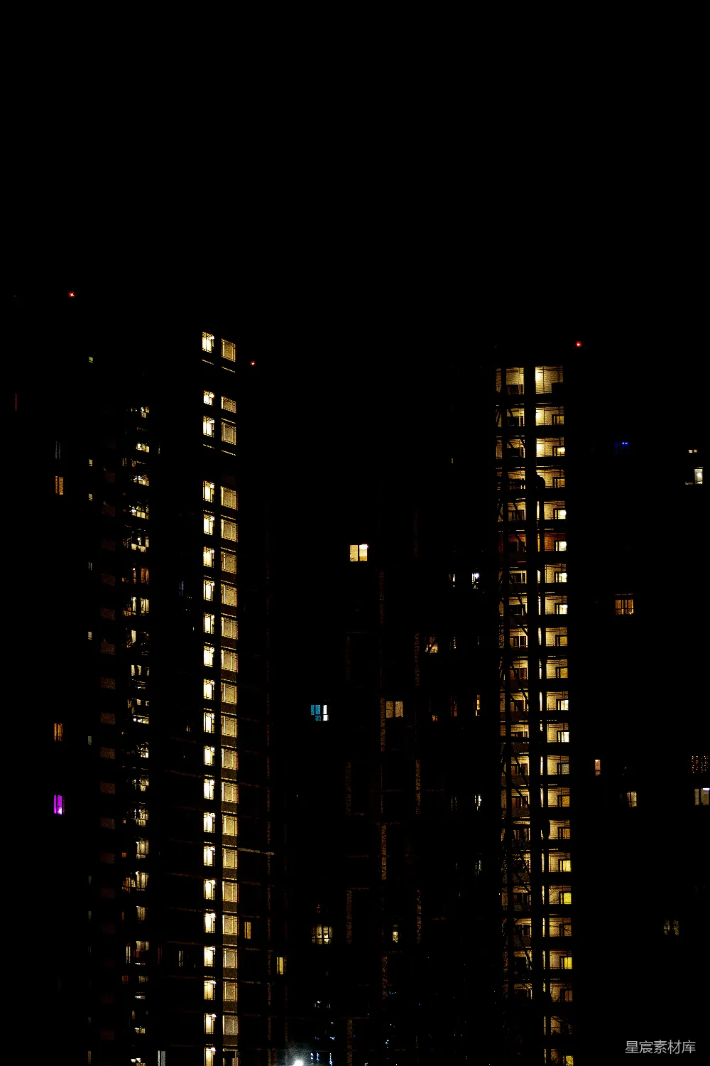 高清摄影  夜晚灯光照亮的公寓楼，窗户闪烁着光亮。