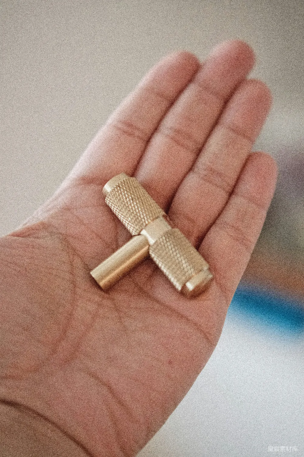 高清摄影  一个人手里拿着一个小金物体。