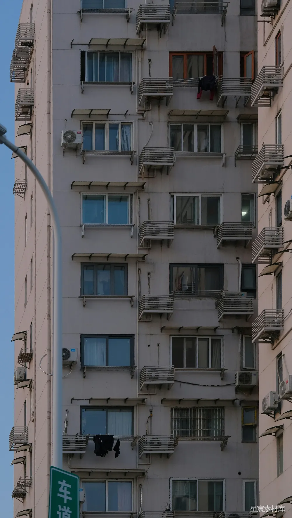 高清摄影  城市公寓建筑外立面，有许多窗户和空调。