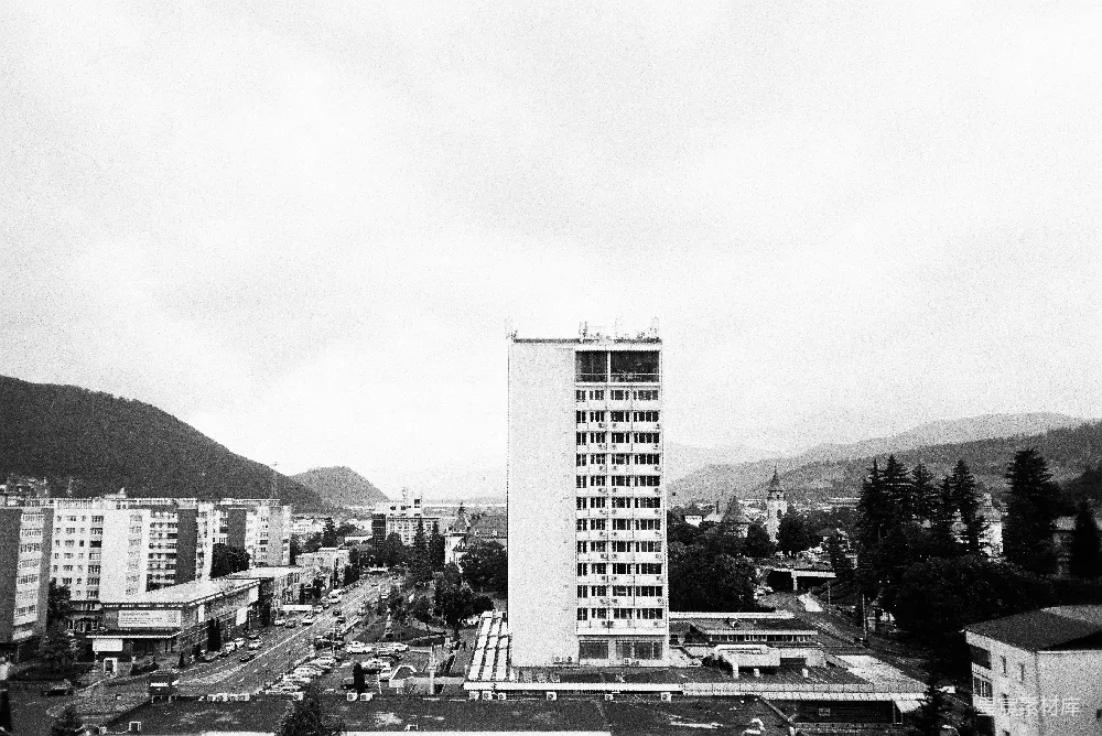 高清摄影  城市景观，其中有一座高楼，道路纵横，周围环绕着山脉。