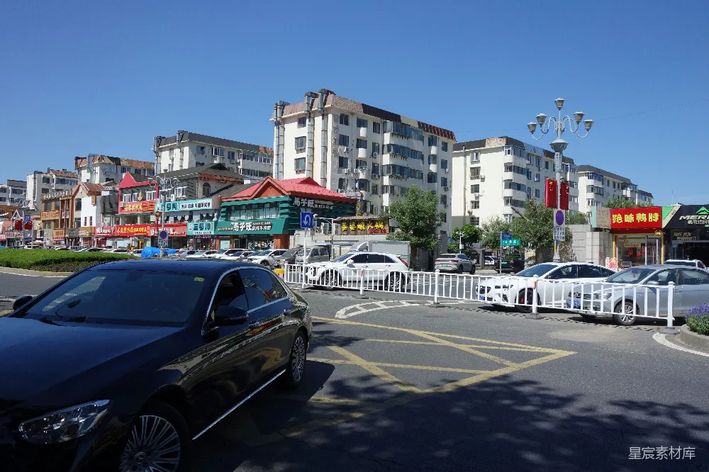高清摄影  城市街道上有车辆、建筑物和明亮的蓝天。