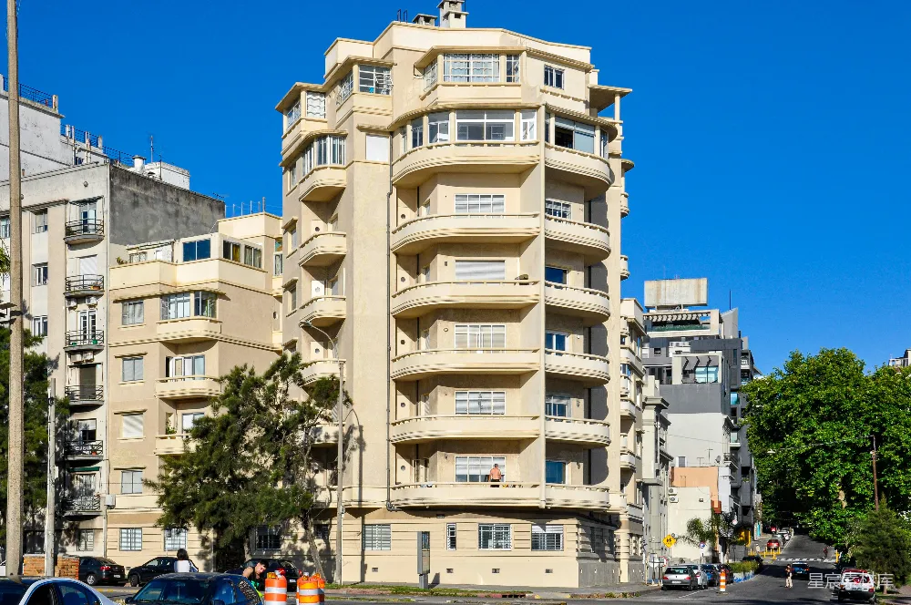高清摄影  一座高大的奶油色建筑，下方有阳台，在蓝天映衬下。