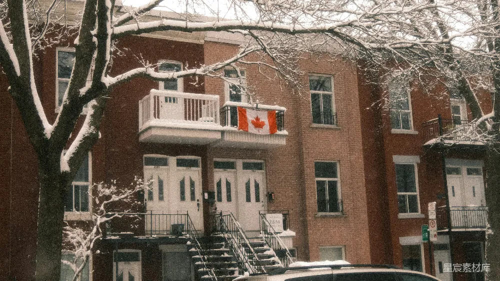 高清摄影  加拿大的国旗挂在有雪的建筑物的阳台上。