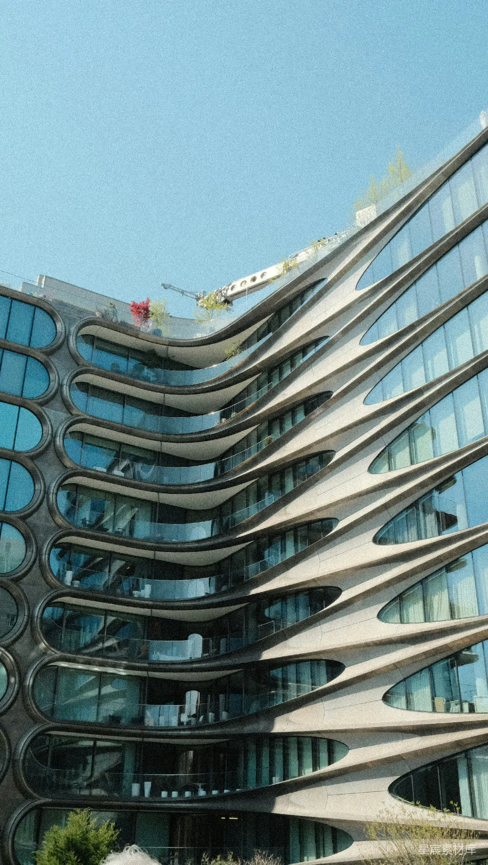 高清摄影  现代化建筑，拥有独特的波浪形外墙和许多玻璃窗。