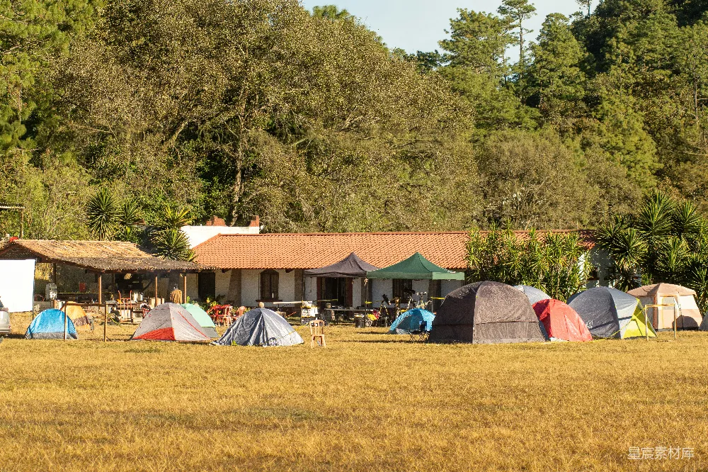 高清摄影  帐篷搭在草地上，建筑物位于其后方。