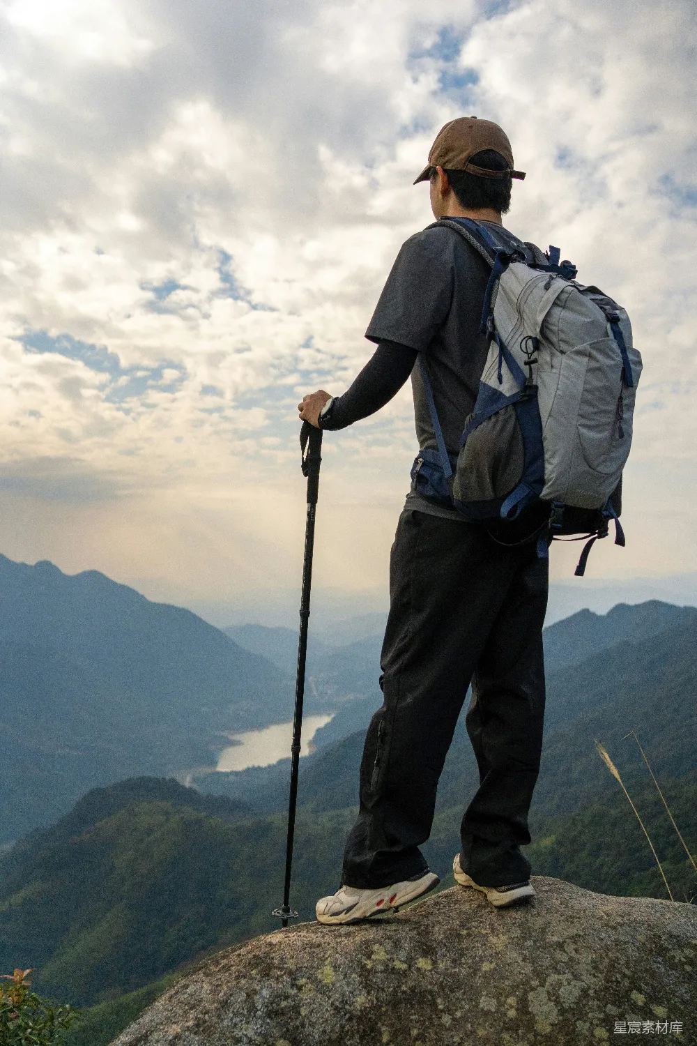 高清摄影  一个背着背包站在山顶上的男人