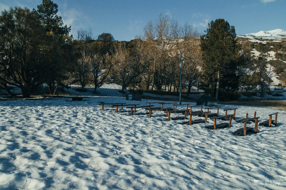 高清摄影  雪地里排列成行的木椅。