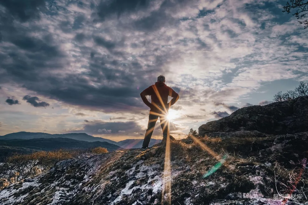 高清摄影  一个男人站在被雪覆盖的小山上。