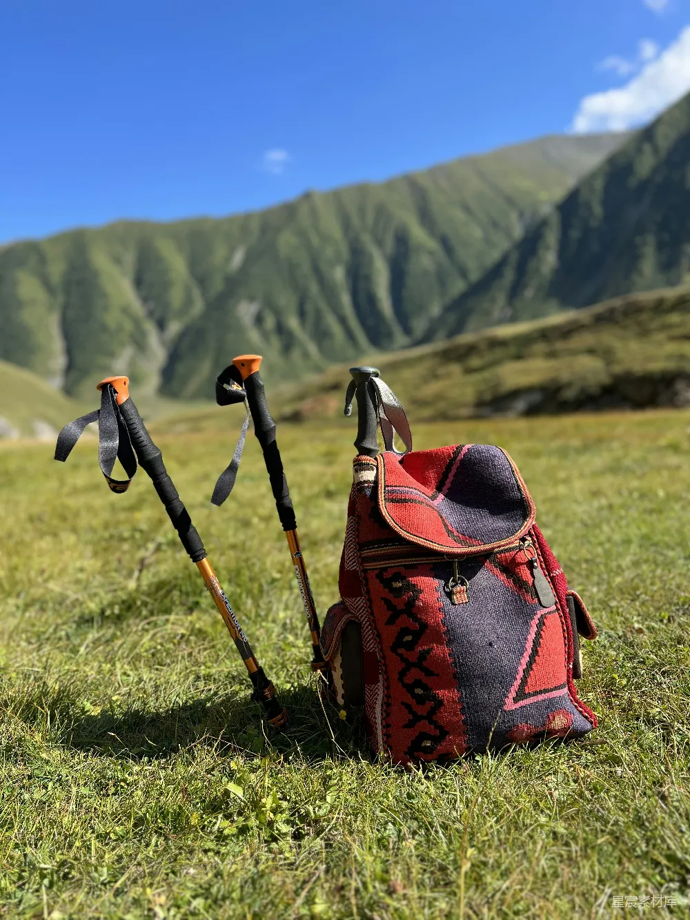 高清摄影 自然 旅行 一双徒步登山杖和一个背包放在草地上