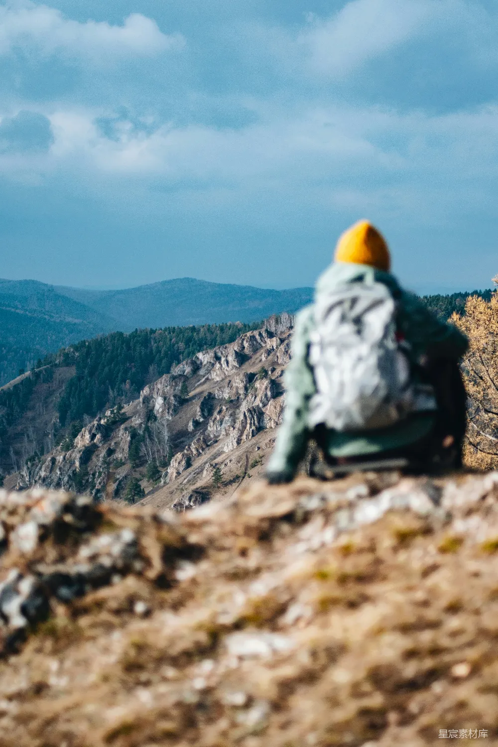 高清摄影 旅行 一个背着背包的人坐在山顶上。