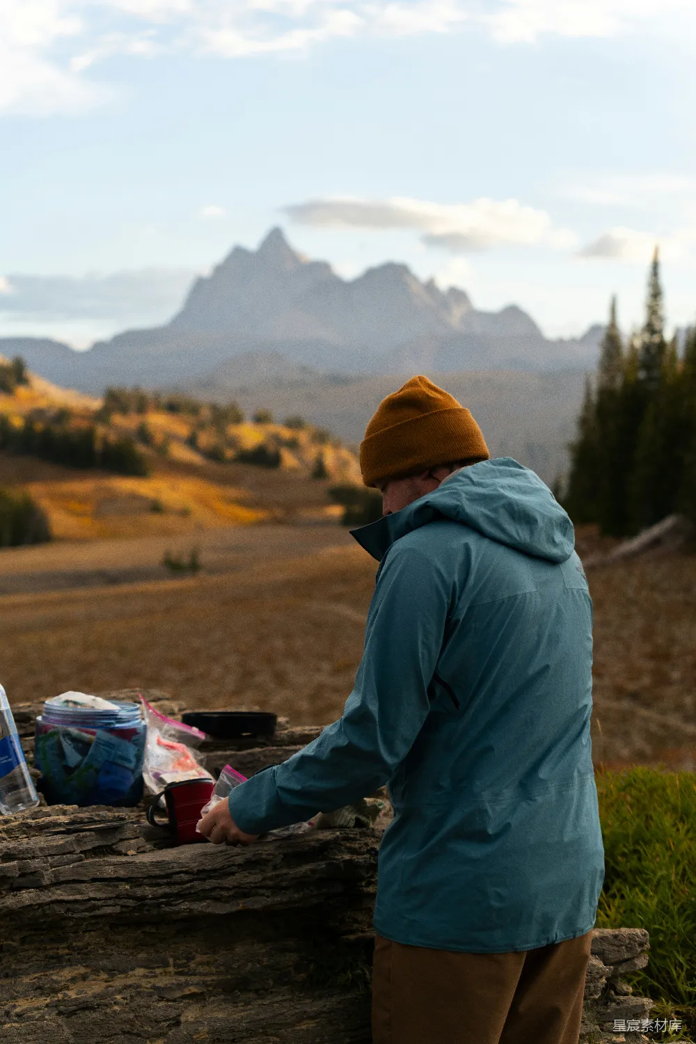 高清摄影  一个人在准备食物，背景中有山脉。
