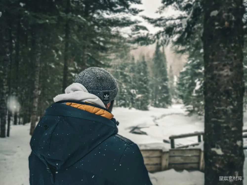 高清摄影  穿黑色夹克和灰色针织帽的人站在被雪覆盖的地面上，白天。