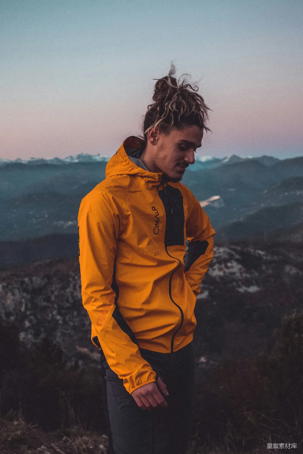 高清摄影 人物 一个穿着黄色夹克的男人站在山顶上。