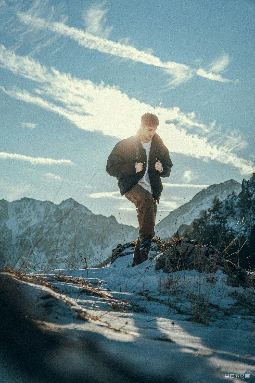 高清摄影 人物 一个男子在晴朗的天空下攀登积雪覆盖的山峰。