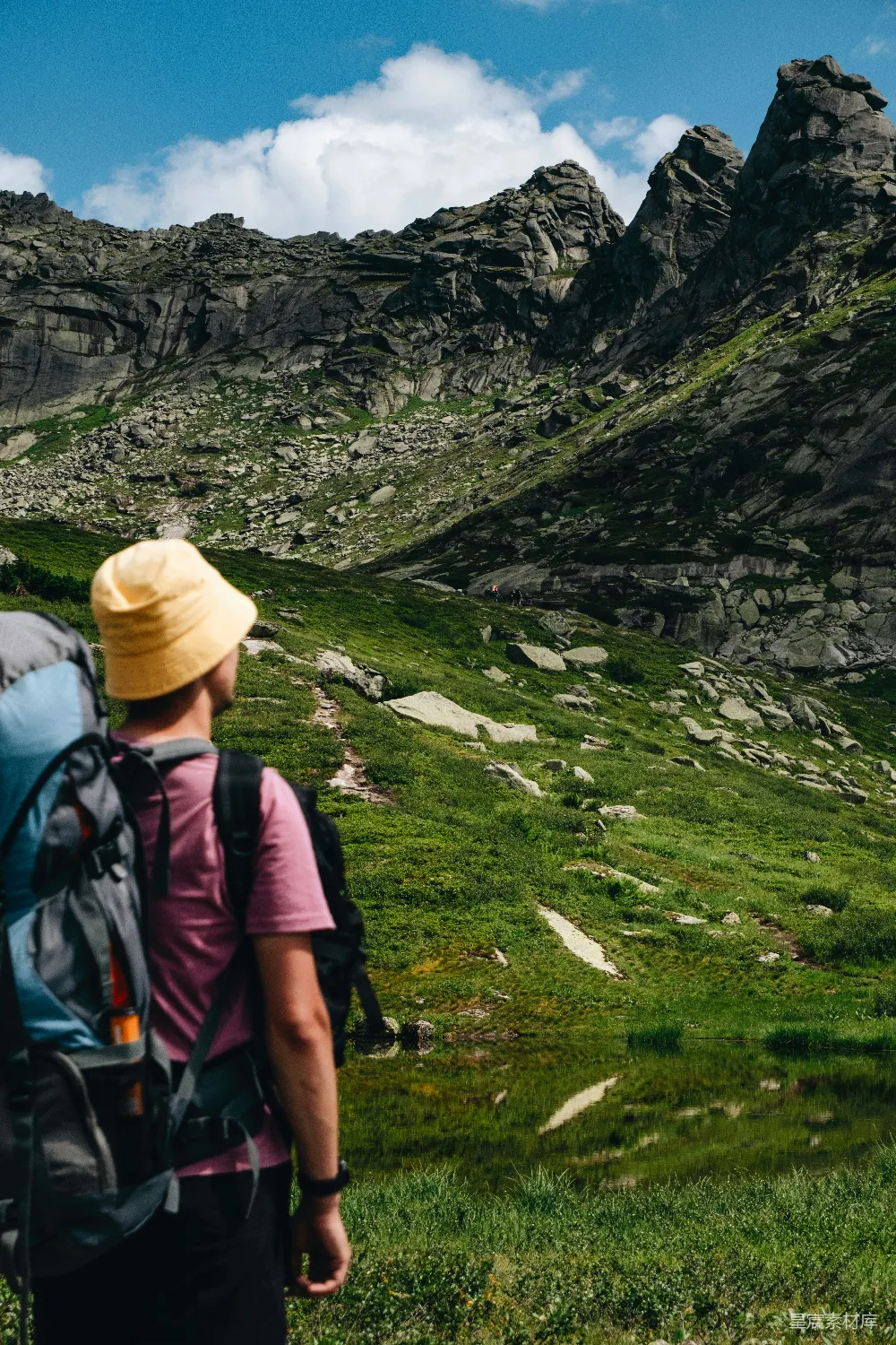 高清摄影 旅行 人物 一个背着背包的男人正沿着山坡往上走。