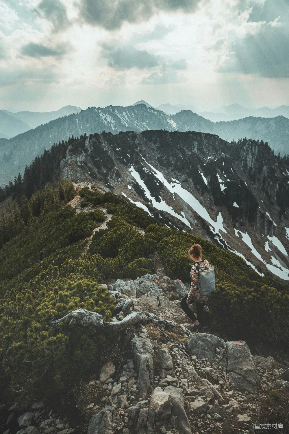高清摄影  白天，一位穿着白色长袖衬衫的女人坐在岩石上，背景是山脉。