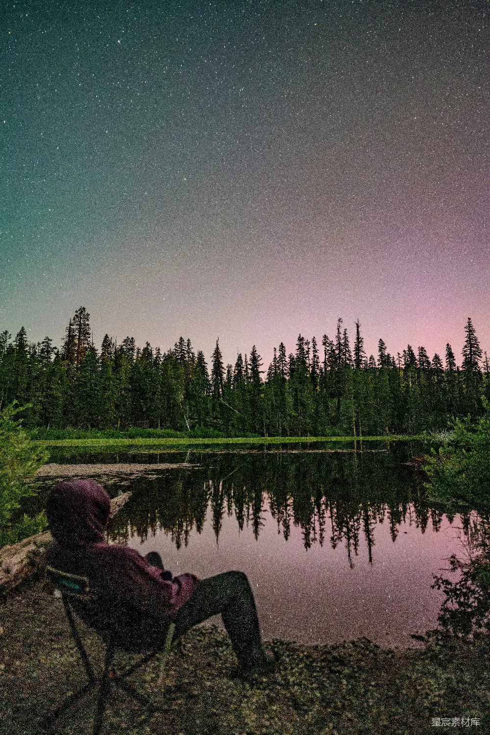 高清摄影  一个人在有反射的湖边观看星空。