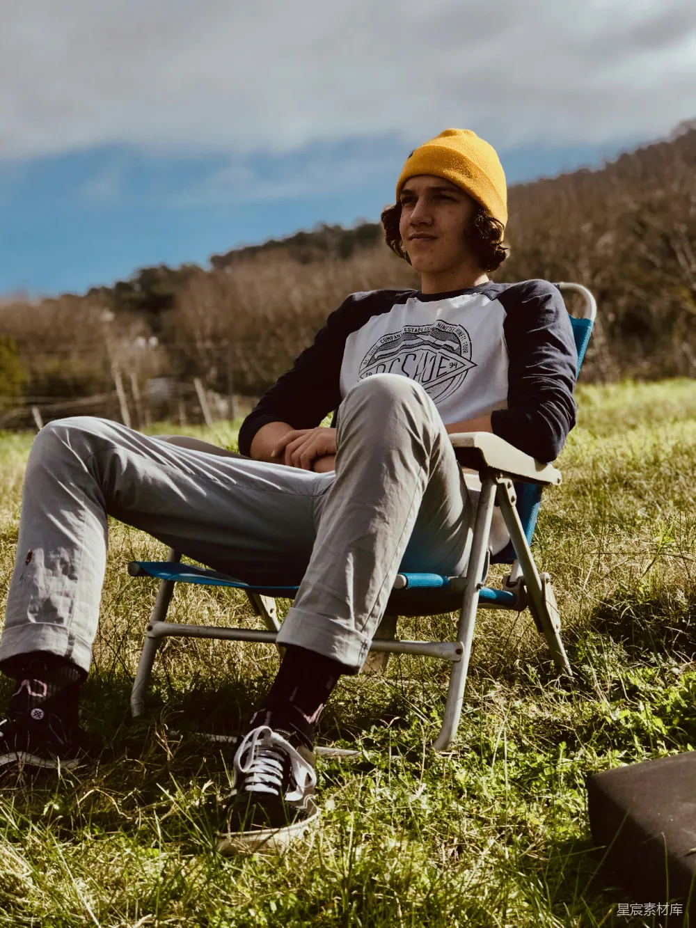 高清摄影  一个男人坐在田野里的椅子上。