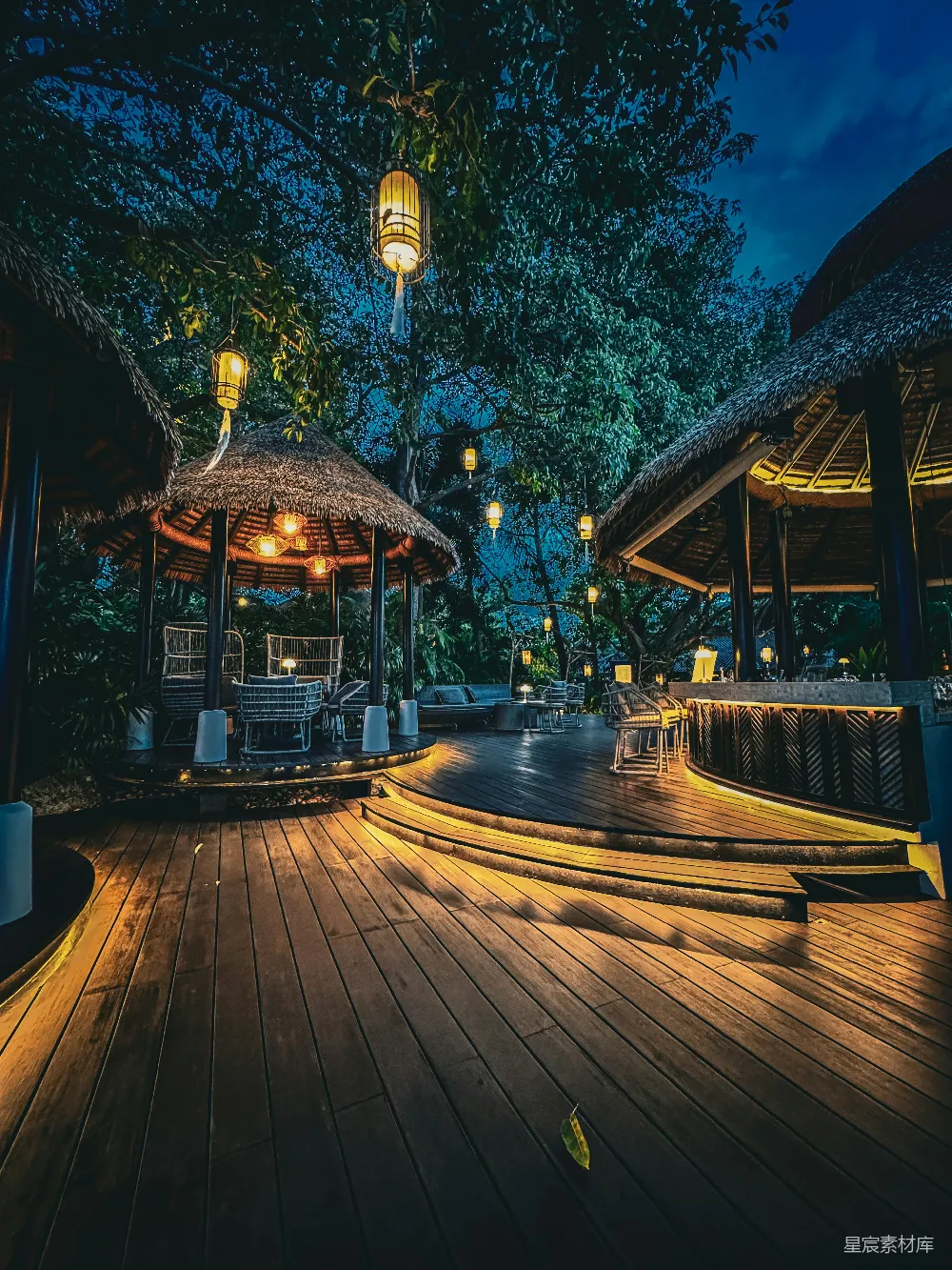 高清摄影  夜晚的热带度假村，灯火辉煌的凉亭和木质露台。