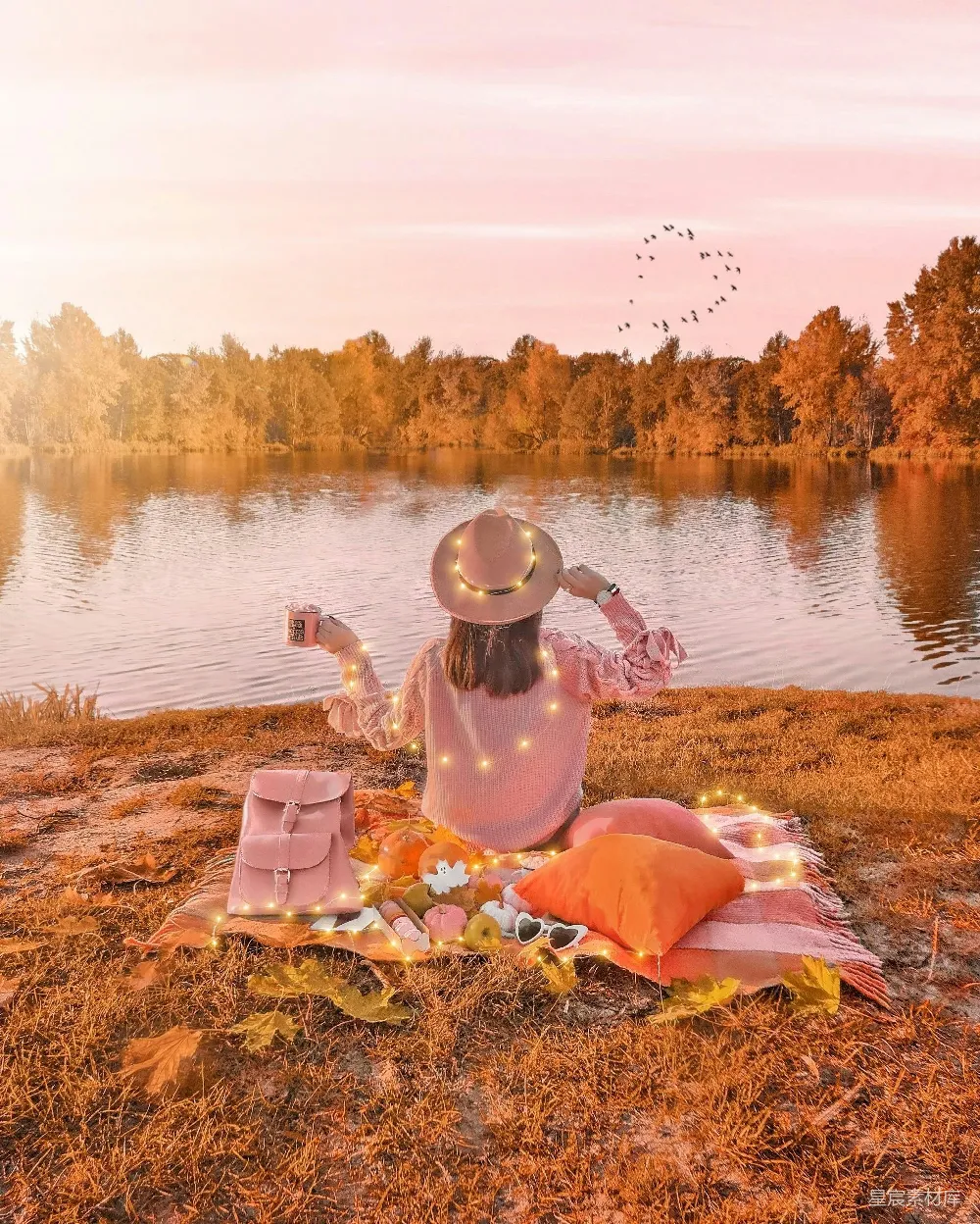 高清摄影  在夕阳下，一个女人在平静的湖边野餐。