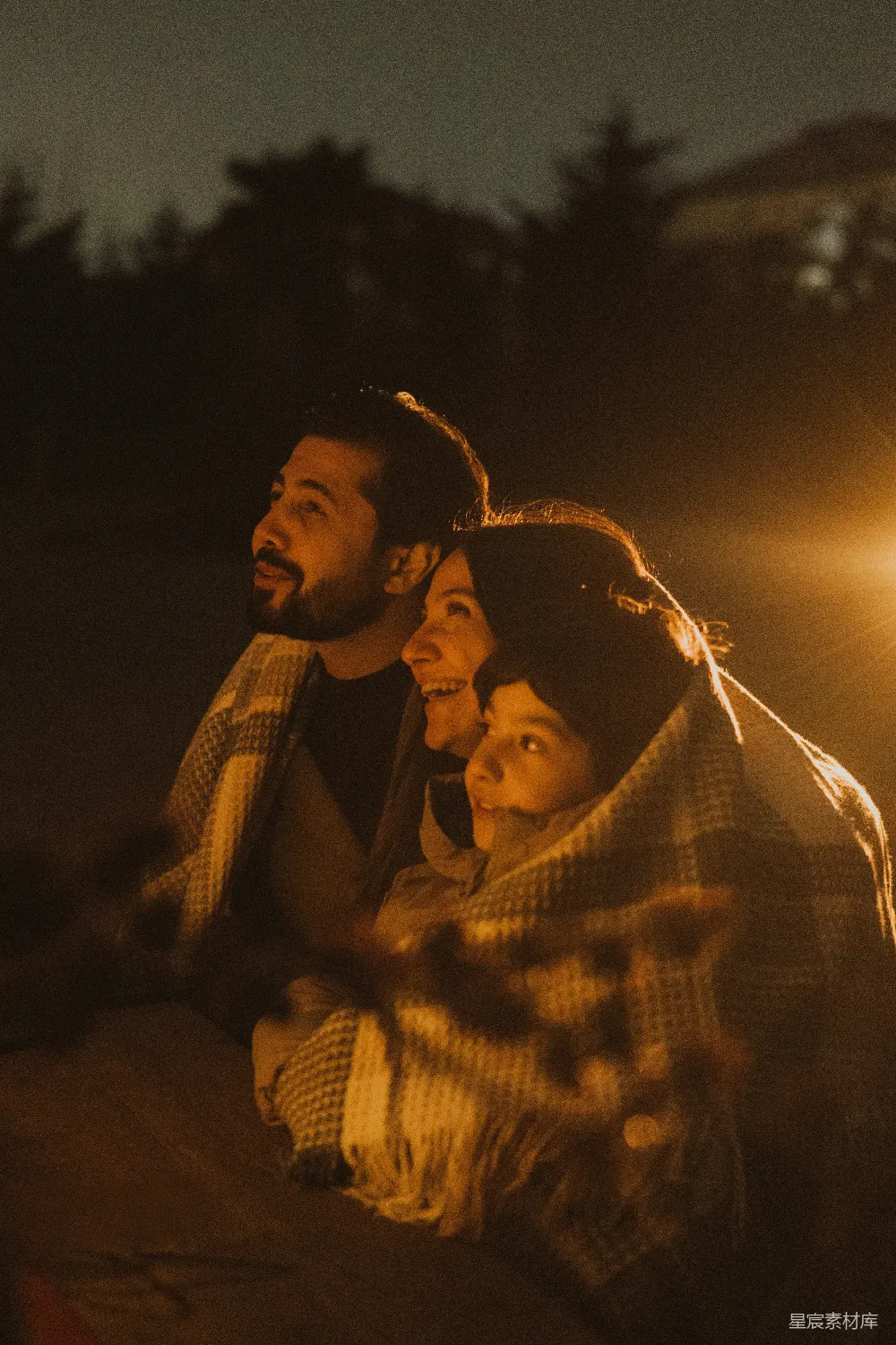 高清摄影  一家人在毯子下看着夜空。