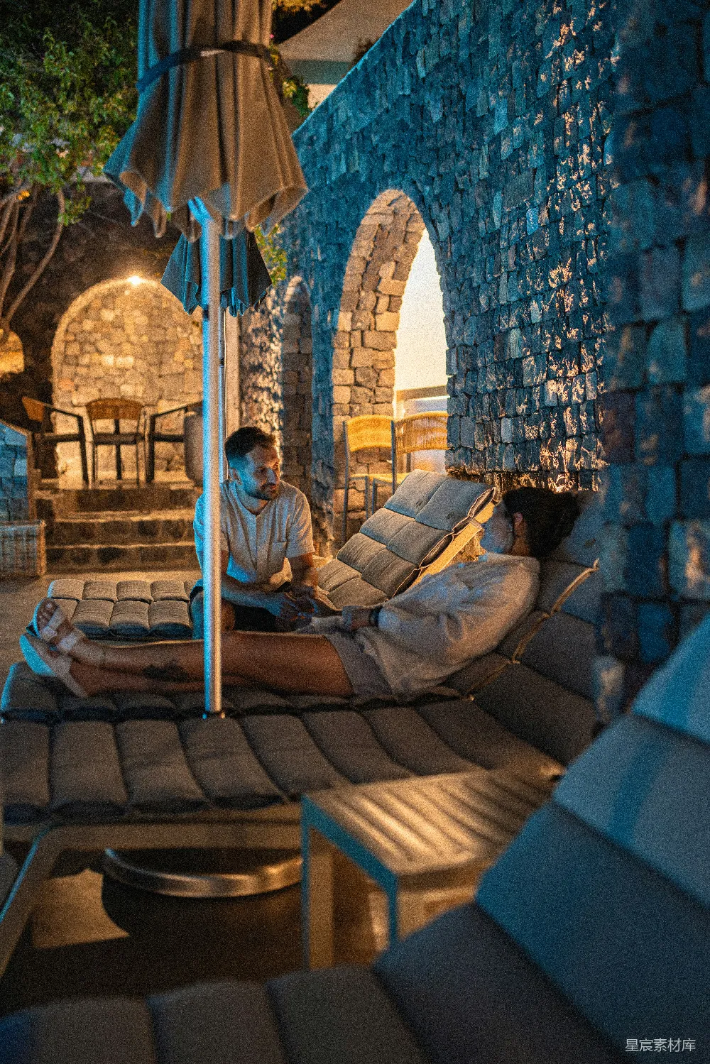高清摄影  两个人在夜晚户外石拱门附近交谈。