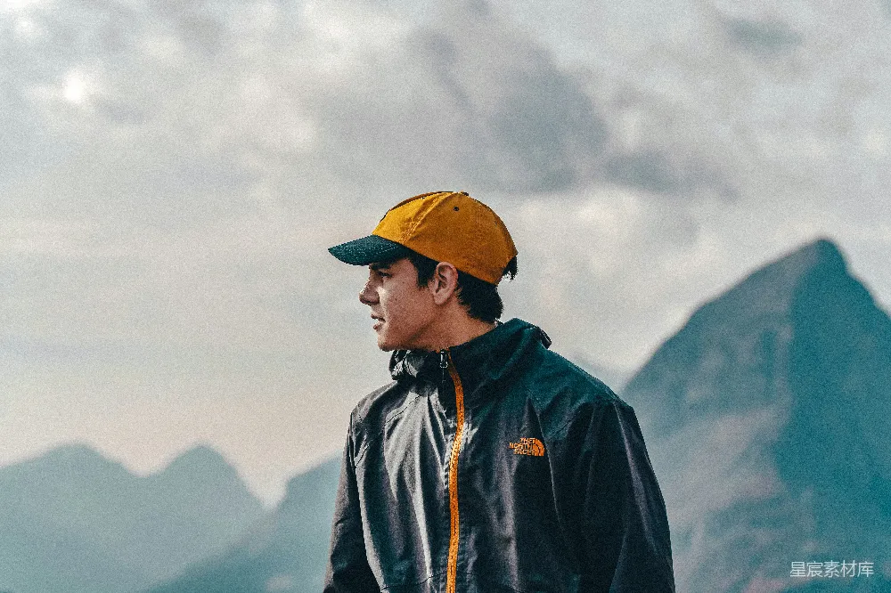 高清摄影 自然 人物 穿着蓝色夹克和黄色帽子的男人站在白天的山上。