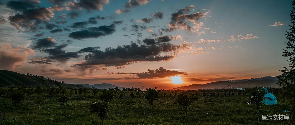 高清摄影  绚丽的夕阳天空映衬着广阔的绿色景观。