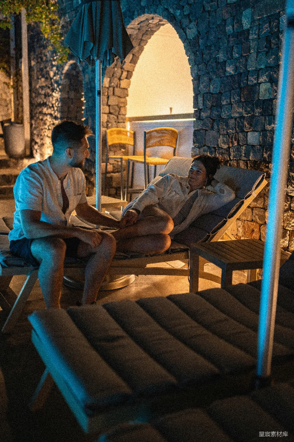 高清摄影  一对夫妇在晚上躺在躺椅上放松。