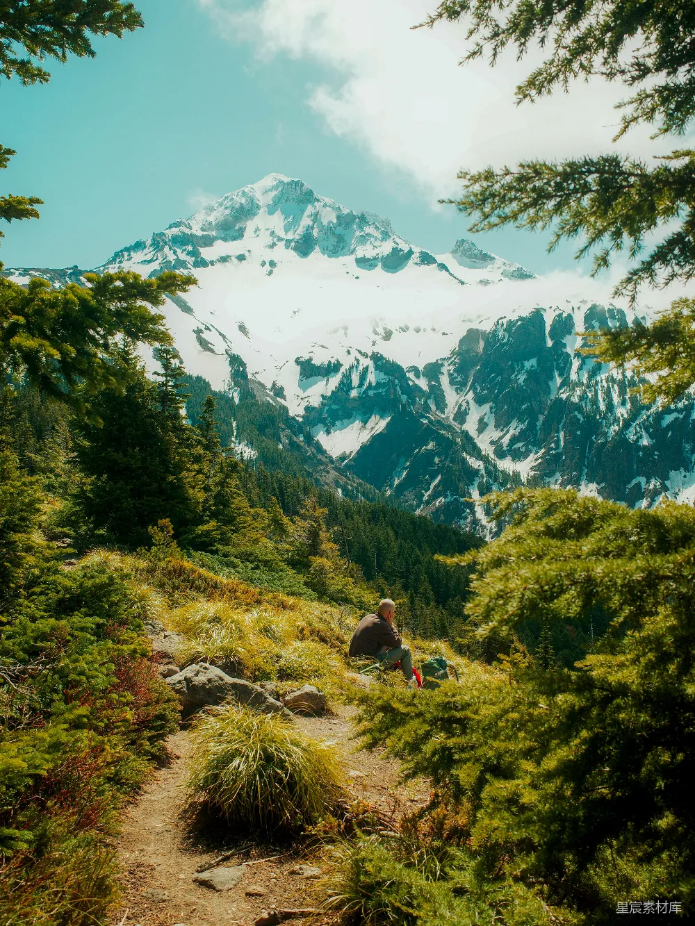 高清摄影 乐观 一个人躺在山路上，俯瞰着雪峰。