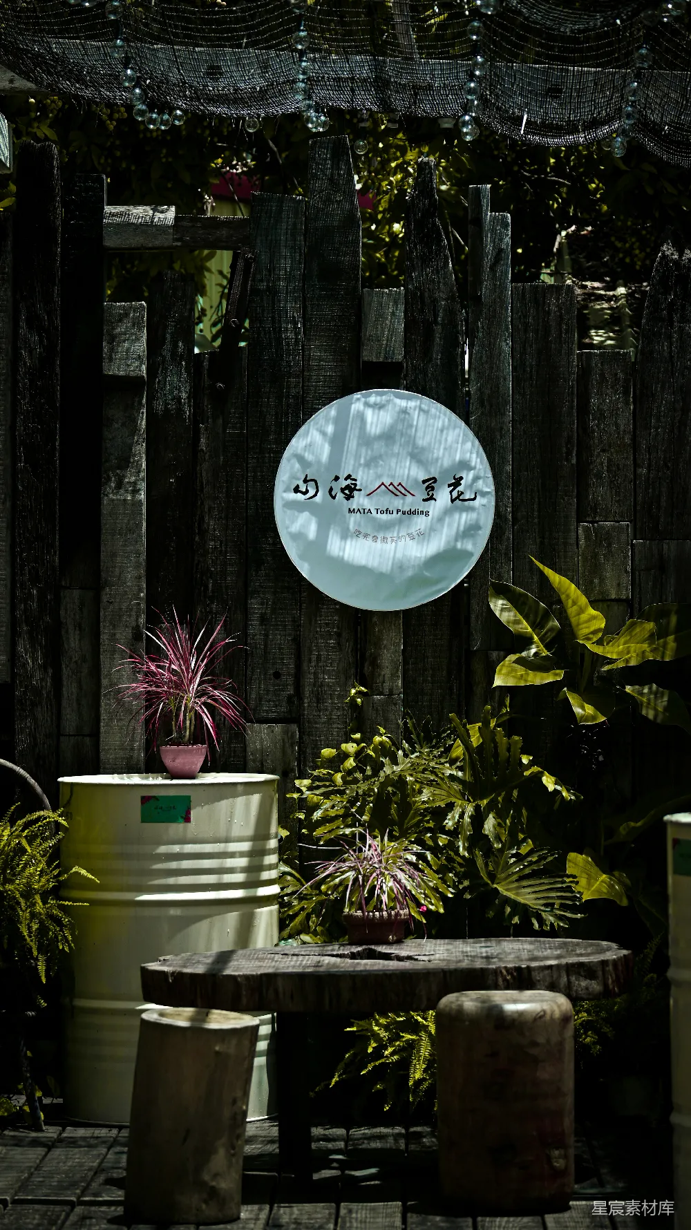 高清摄影  乡村风格的户外休息区，配有植物和木桶。